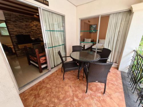 a dining room with a table and chairs on a balcony at Palmas Del Mar Resort Bacolod in Bacolod