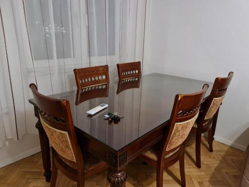 a dining room table with four chairs around it at Apartment for Rent in Gjilan