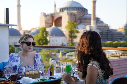 two women sitting at a table with food at Turk Art Hotel in Istanbul