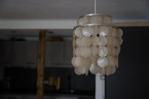 a chandelier with white balls hanging from a ceiling at Cosy & Style Zell am See in Schmitten