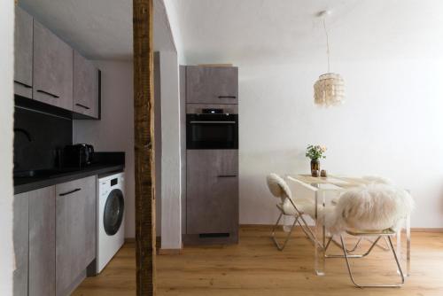 a kitchen with a table and chairs in a room at Cosy & Style Zell am See in Schmitten