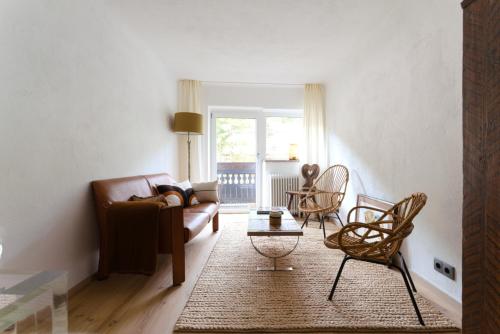 a living room with a brown couch and chairs at Cosy & Style Zell am See in Schmitten