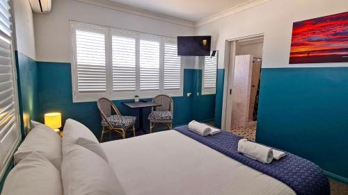 a bedroom with a large bed and a table at Sawtell Hotel in Sawtell