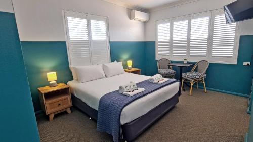 a bedroom with a bed and a table and chairs at Sawtell Hotel in Sawtell
