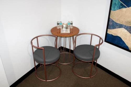 a table with two chairs and a table with water bottles on it at Dancenter Boss Hotel Near Clark International Airport in Angeles
