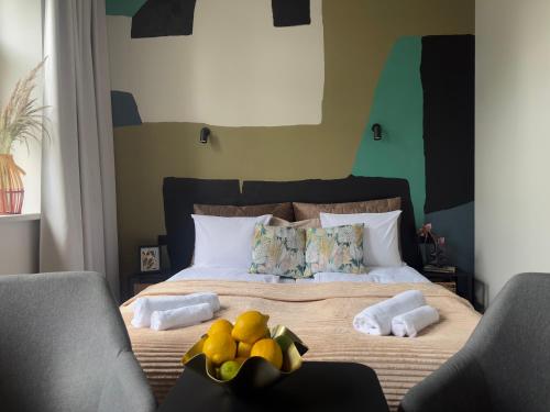 a bedroom with a bed with two chairs and fruit on it at RixStay Apartments in Rīga
