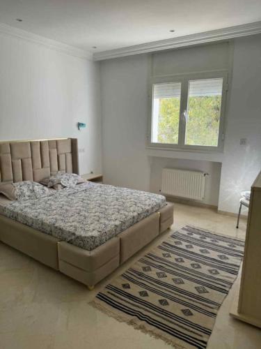 a bedroom with a large bed and a rug at Sunny Villa Apartment, 10min Walk to La Marsa Beach in Dar Tahar Zaouch