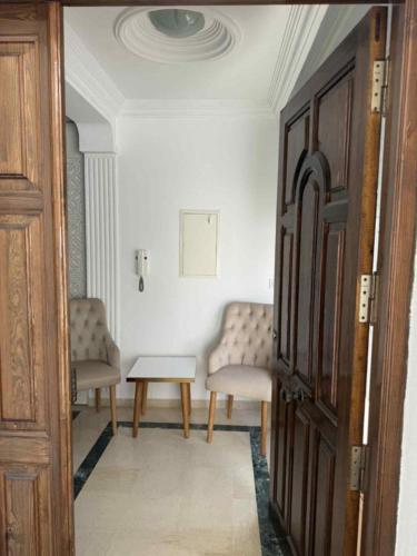 a room with two chairs and a table and a door at Sunny Villa Apartment, 10min Walk to La Marsa Beach in Dar Tahar Zaouch