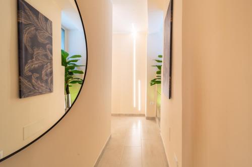 een hal met een ronde spiegel aan de muur bij Desiree Luxury House- vasca idromassaggio in Catania