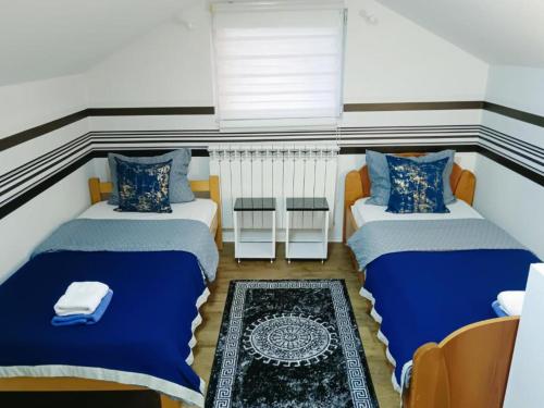 ein kleines Zimmer mit zwei Betten und einem Tisch in der Unterkunft Apartments Center HSV in Novi Sad