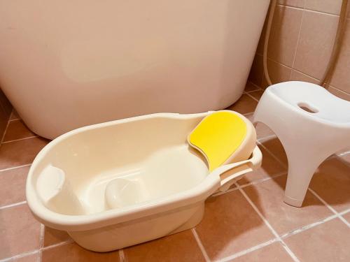 a toilet with a yellow seat in a bathroom at 最大14名 広さ140平米 おもろまち駅免税店3分 国際通り栄町5分 駐車場2台付き casa joshua カーサ ジョシュア in Naha