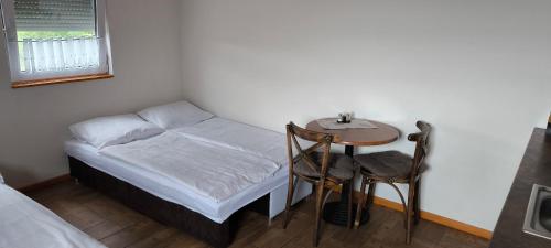a small bedroom with a small table and a bed at Ceremoniár in Poľný Kesov