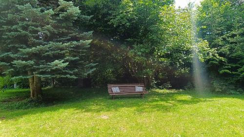 a park bench sitting in the grass in a field at Zacisze Stasia Ustroń 