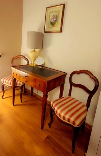 a desk and a chair next to a table and a lamp at Zacisze Stasia Ustroń 