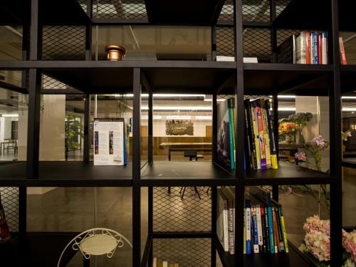 a book shelf filled with books in a room at iChapter Hotel Suvarnabhumi in Samutprakarn