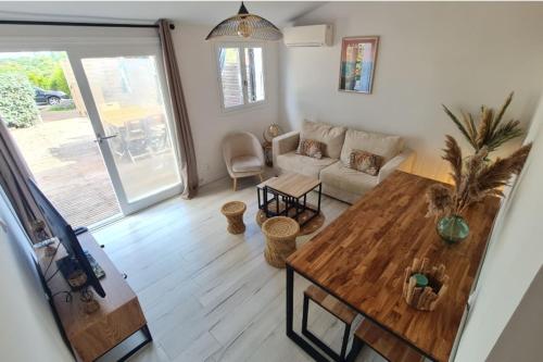 un soggiorno con un tavolo e un divano di Charming house with terrace and pool a Porticcio