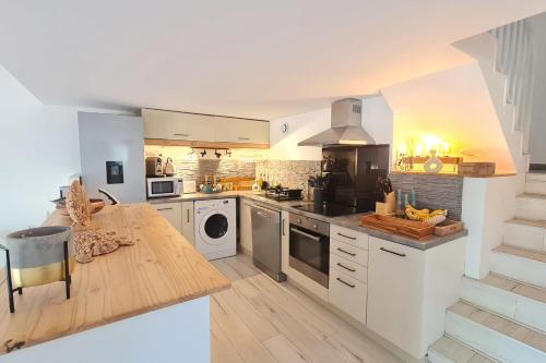 - une cuisine avec des appareils blancs et un comptoir en bois dans l'établissement Charming house with terrace and pool, à Porticcio