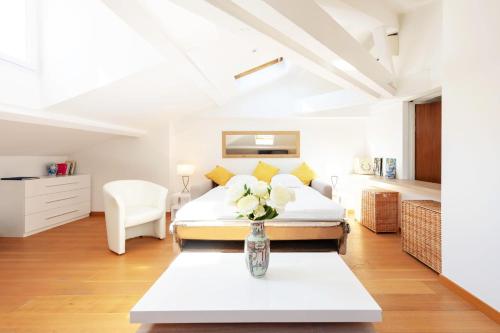 une chambre avec un lit et une table avec un vase de fleurs dans l'établissement Luxurious StudioLoft 3 MINUTES FROM LA CROISETTE, à Cannes