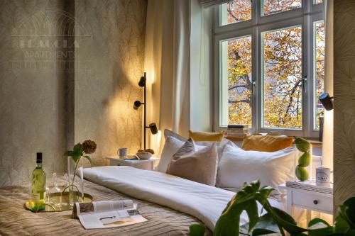 a bedroom with a bed with white pillows and a window at Fragola Apartments Old Town in Kraków