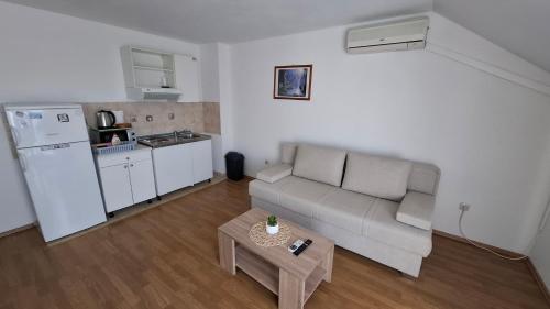 a living room with a couch and a kitchen at Apartments Mato with balconies, garden & the sea view in Seget Vranjica