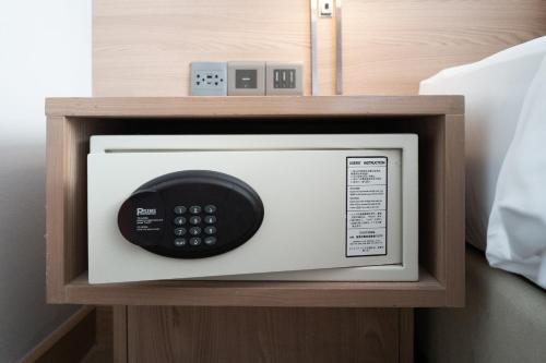 a microwave with a remote control on top of it at Kritthai Residence in Bangkok