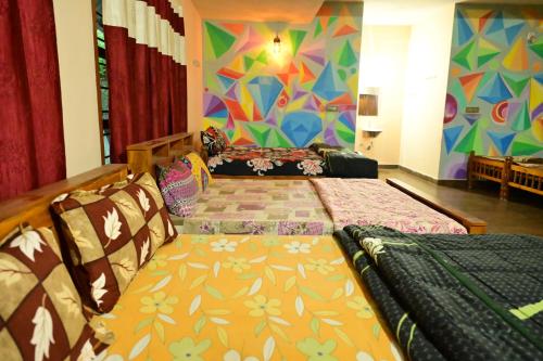 a bedroom with two beds and a colorful wall at DELIGHTFUL HOMESTAY in Sollebail
