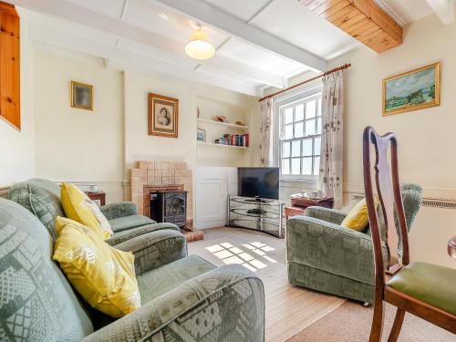 a living room with couches and a fireplace at Memory Cottage in Mevagissey