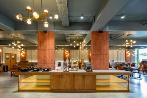 a restaurant with a large island in the middle of a room at Hotel Veritas Grand in Sānand