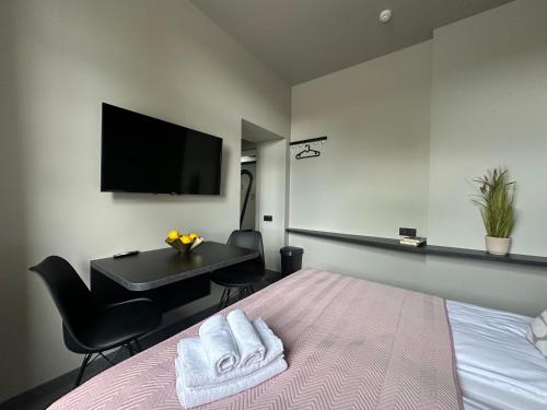 a bedroom with a bed and a desk and a television at RixStay Apartments in Rīga