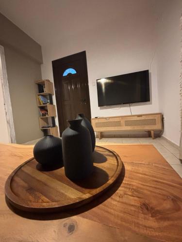 メガリ・アモスにあるLily's Guest Houseの木製のテーブルの上に2つの黒い花瓶が置かれた部屋