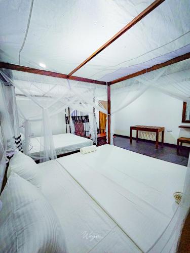 a bedroom with two beds in a tent at Banana Shade Cottage in Udawalawe