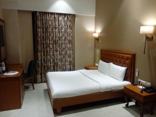 a bedroom with a white bed and a window at The Hub Link in Mumbai