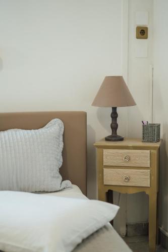 a bed with a night stand with a lamp on it at Spacious Apartment in Mytilene in Mytilini
