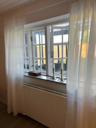 a window with white curtains in a room at Charming House With Beautiful Views in Gedser