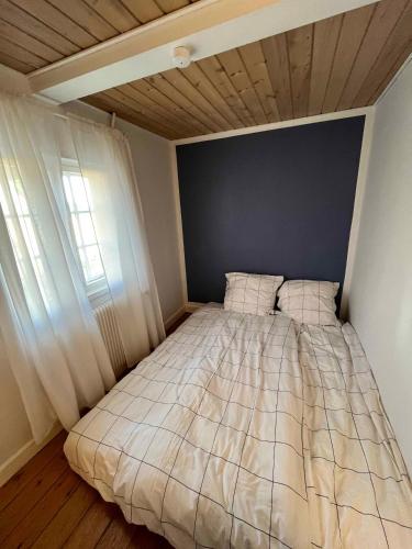 a bed in a small room with a window at Charming House With Beautiful Views in Gedser
