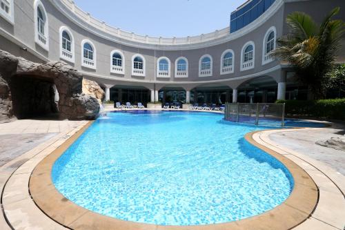 a large swimming pool in a building at Sharjah Premiere Hotel & Resort in Sharjah