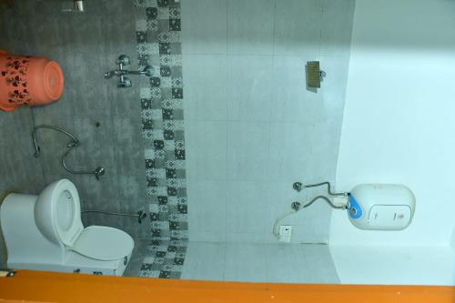 a bathroom with a toilet and a shower at Hotel Hari Radhe 