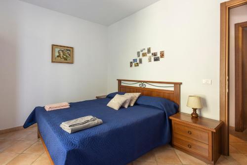 a bedroom with a blue bed and a night stand at U Ciousu by Ligurian Life APPARTAMENTI IN AGRITURISMO in Vallebona