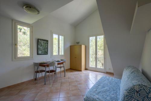 a room with a bed and a table and chairs at U Ciousu by Ligurian Life APPARTAMENTI IN AGRITURISMO in Vallebona
