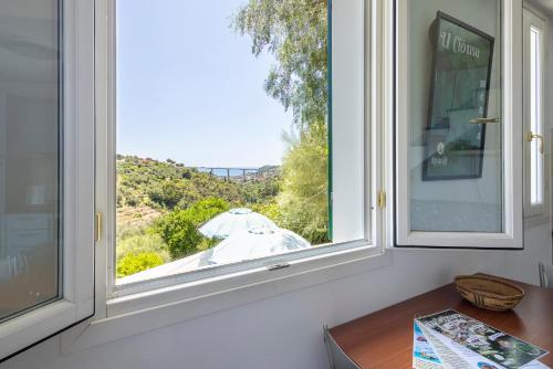 a window in a room with a view of an umbrella at U Ciousu by Ligurian Life APPARTAMENTI IN AGRITURISMO in Vallebona