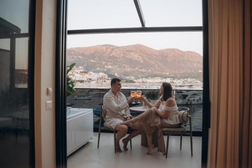 a man and woman sitting at a table drinking wine at Rea Boutique Hotel in Himare