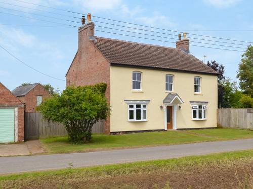 a yellow house on the side of a road at Homestead in Long Sutton