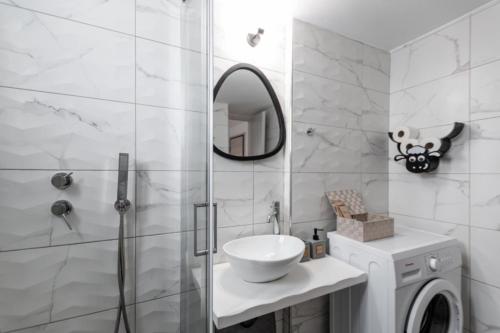 a bathroom with a sink and a shower with a mirror at heliaia2 in Naxos Chora