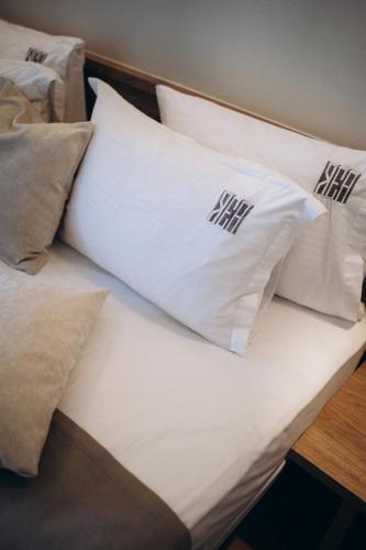 a bed with white pillows on top of it at Rea Boutique Hotel in Himare