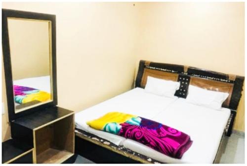 a bedroom with a bed and a mirror at Hotel Aliza Palace Ajmer AC OR NON AC ROOM in Ajmer