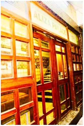a store with wooden doors and windows on a building at Hotel Aliza Palace Ajmer AC OR NON AC ROOM in Ajmer