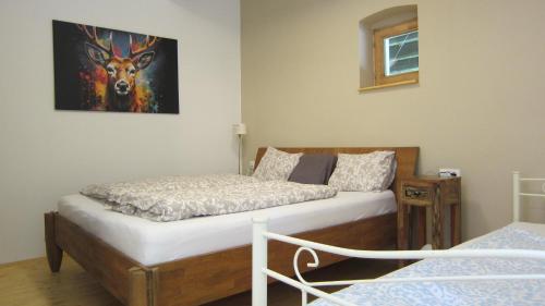 a bedroom with two beds and a painting of a deer at Gara Cottage Private escape with modern comfort and spacious covered terrace in Garabonc