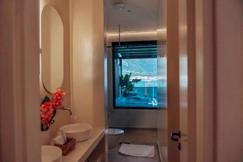 a bathroom with a sink and a toilet and a window at Rea Boutique Hotel in Himare