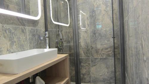 a bathroom with a sink and a shower at Gara Cottage Private escape with modern comfort and spacious covered terrace in Garabonc