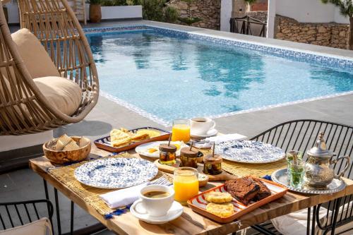 a table with food and drinks next to a swimming pool at Villa Sahel Bleu in Essaouira